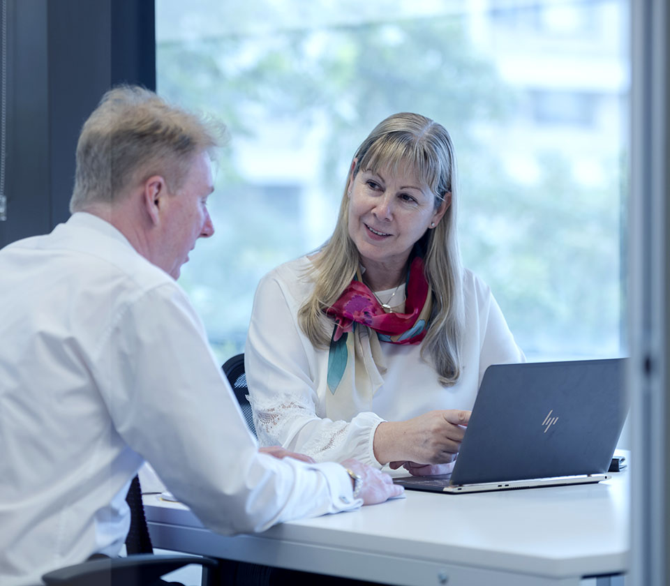 Business meeting with male Managing director and founding partner Neill Brennan speaking to female Chief Executive Officer and CEO Mira Brennan in Australia Sydney office