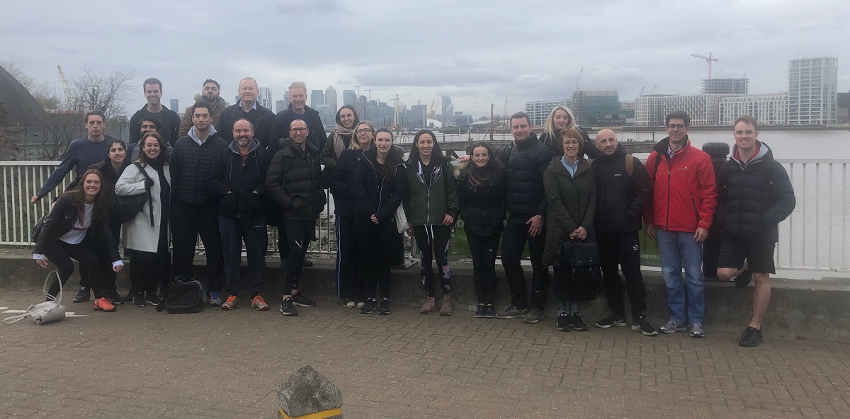 group photo of London Augusta staff standing next to river during a cold and foggy day