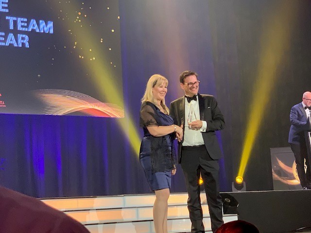 CEO Mira Brennan presenting award to winning law firm on stage at the Australian awards show