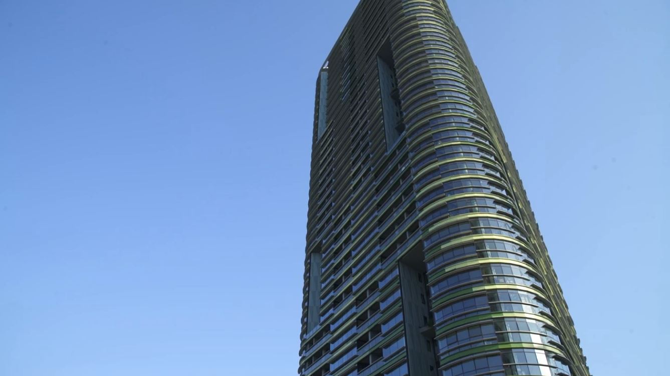 Large skyscraper the Opal Tower, resident building in Sydney Australia towering over streets with blue clear sky